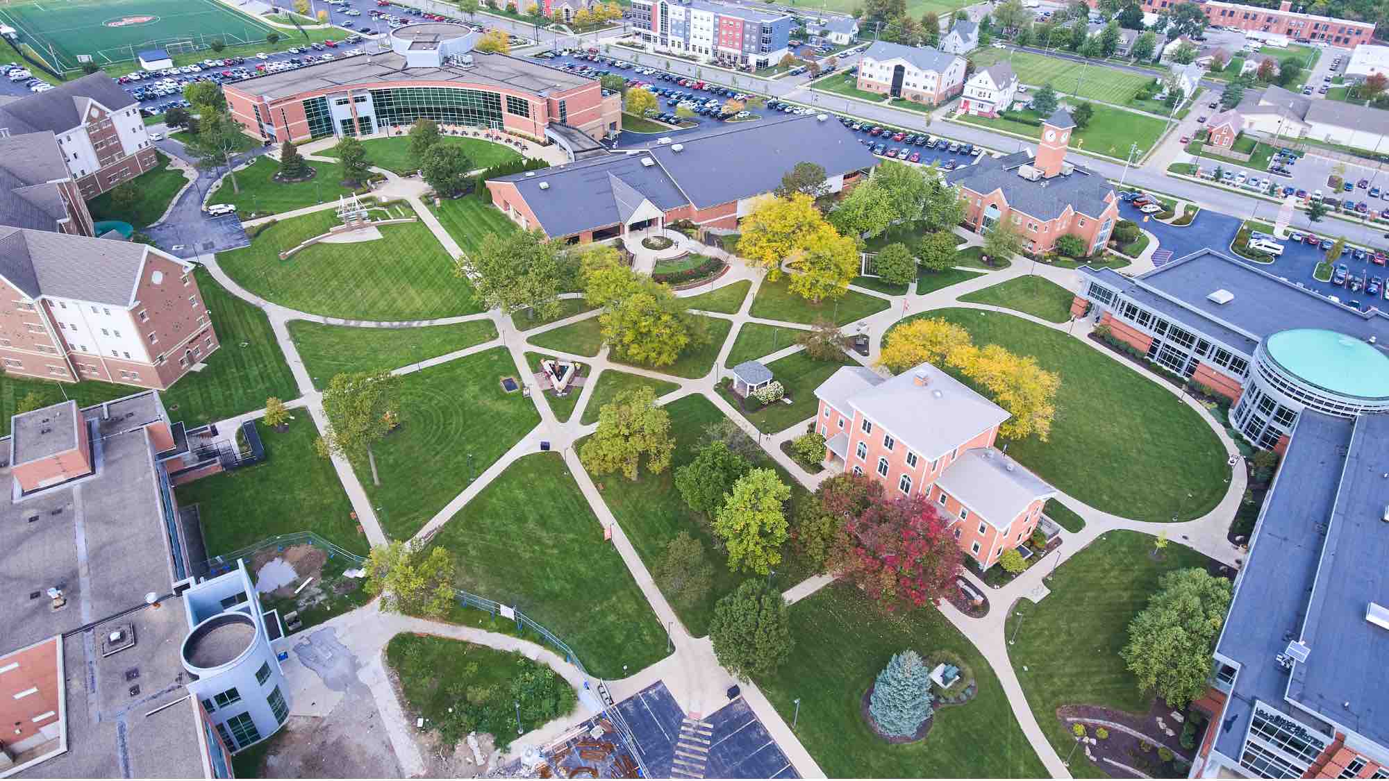 Ariel view of a campus showing buildings around a pedestrian area with sidewalks.